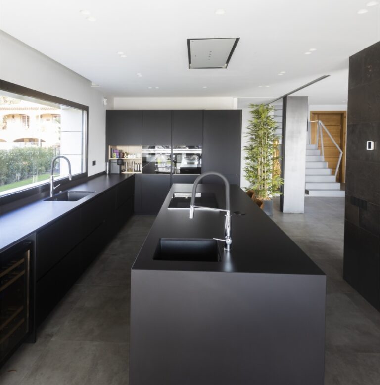 Cocina con isla central y frentes oscuros