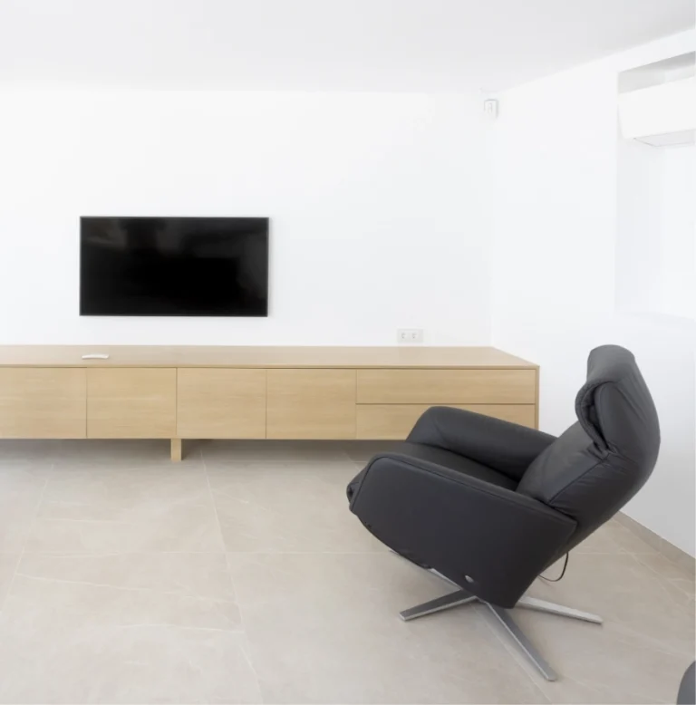 Zona de estar diáfana con mueble bajo de madera