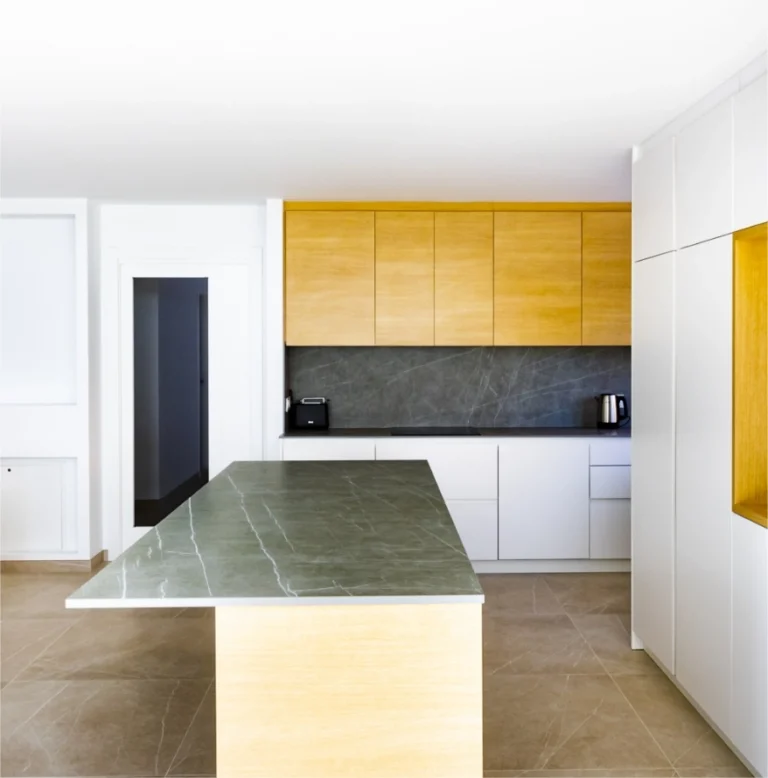 Cocina con isla de encimera de piedra verde y frentes de madera
