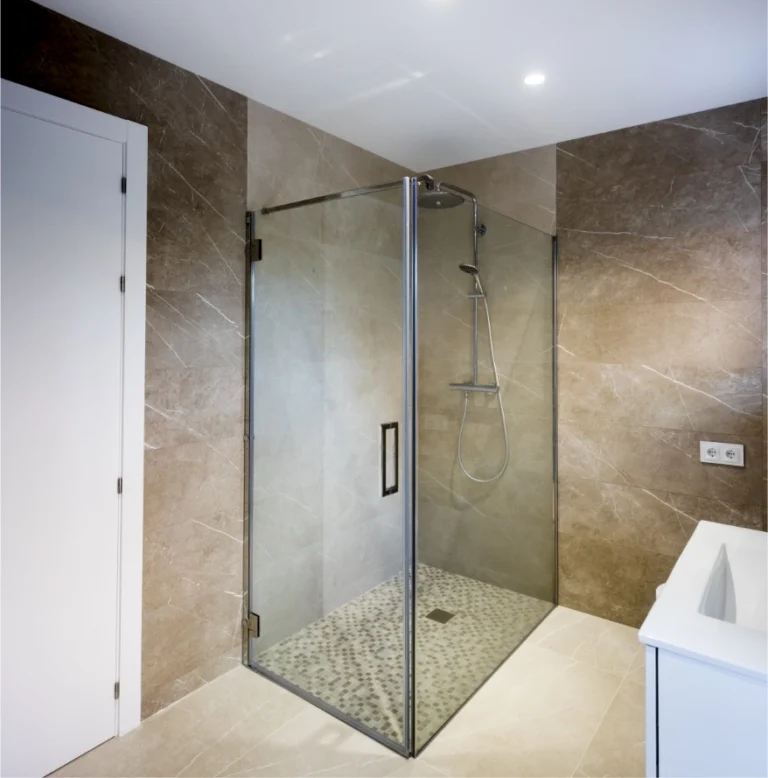 Baño con ducha de obra y mampara de vidrio