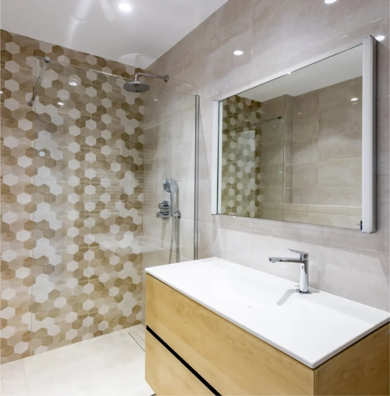 Baño con revestimiento cerámico hexagonal y mueble de madera