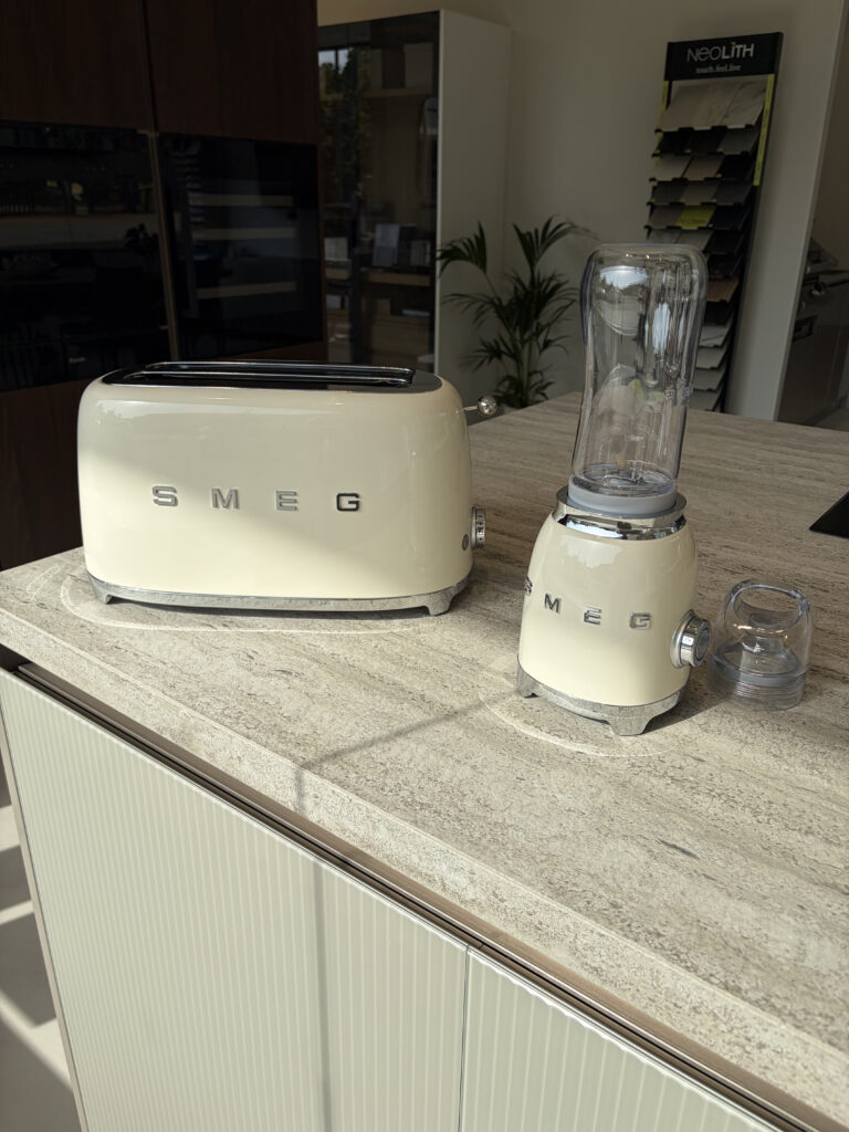 Electrodomésticos Smeg sobre encimera de mármol en el showroom de Amplitud Studio