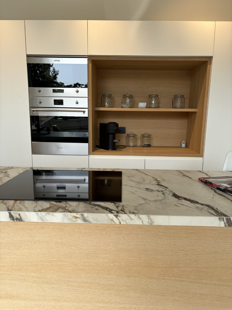 Columna de hornos y encimera de mármol en el showroom de cocinas de Amplitud Studio